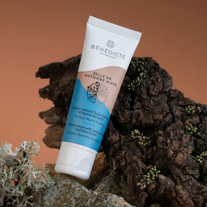 Mise en scène de la crème à mains Automne Hiver de Bénédicte avec en fond un dégradé marron