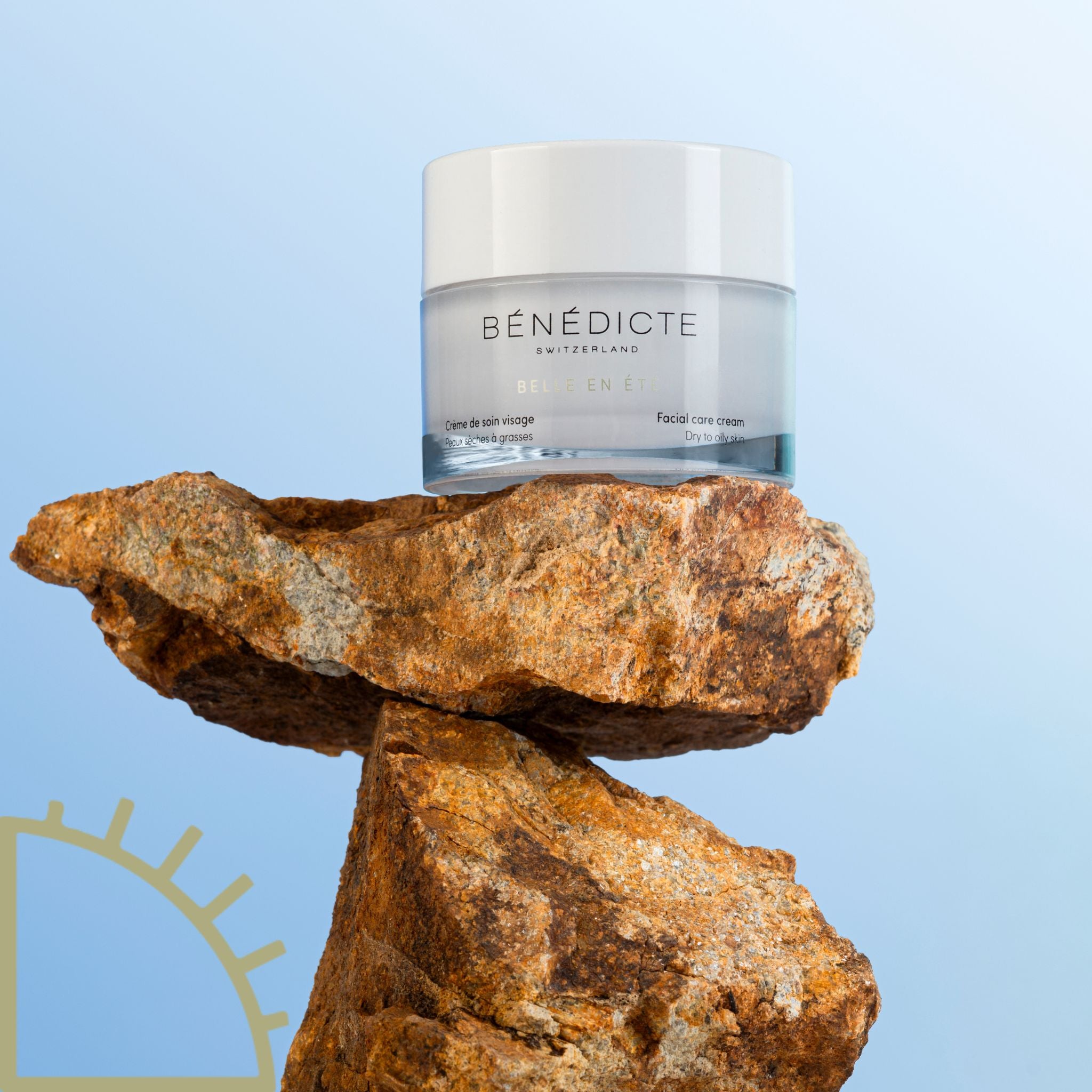 Pot de crème Belle en Été Bénédicte posée sur une roche sur un fond dégradé bleu