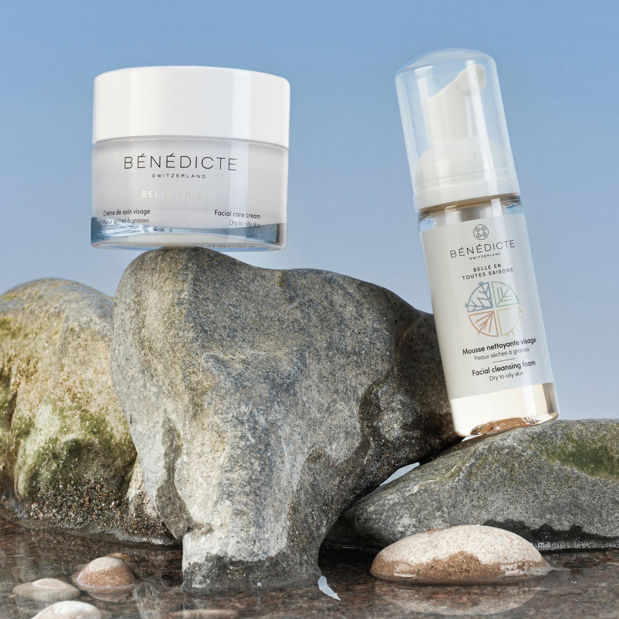 Visuel de la crème Belle en Été et de la mousse nettoyante photographiés sur de la roche avec de l'eau et sur fond bleu