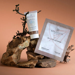 Visuel du gommage et du masque automne photographiés sur de la roche sur un fond marron