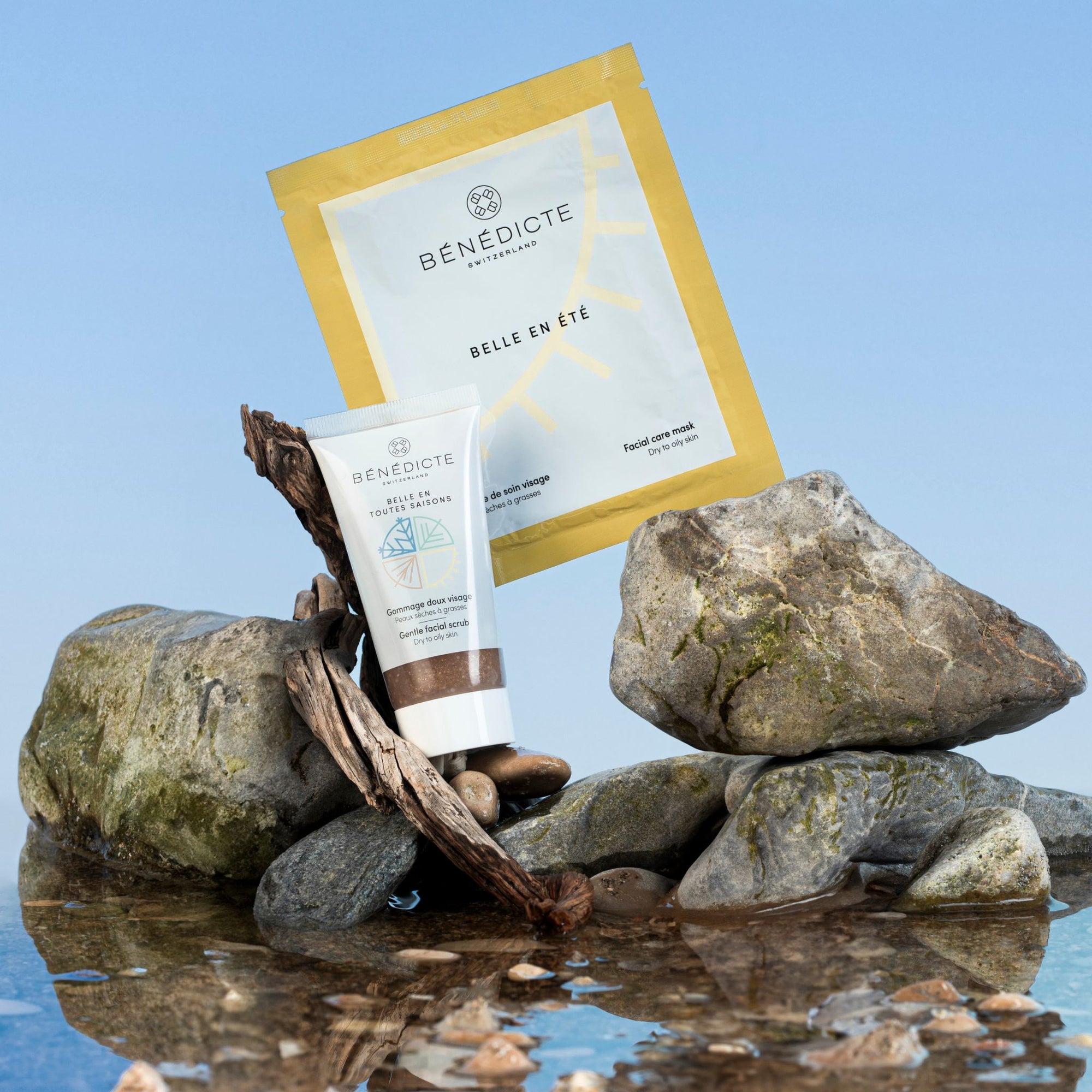 Visuel du gommage et du masque été photographiés sur des galets avec de l'eau sur un fond bleu