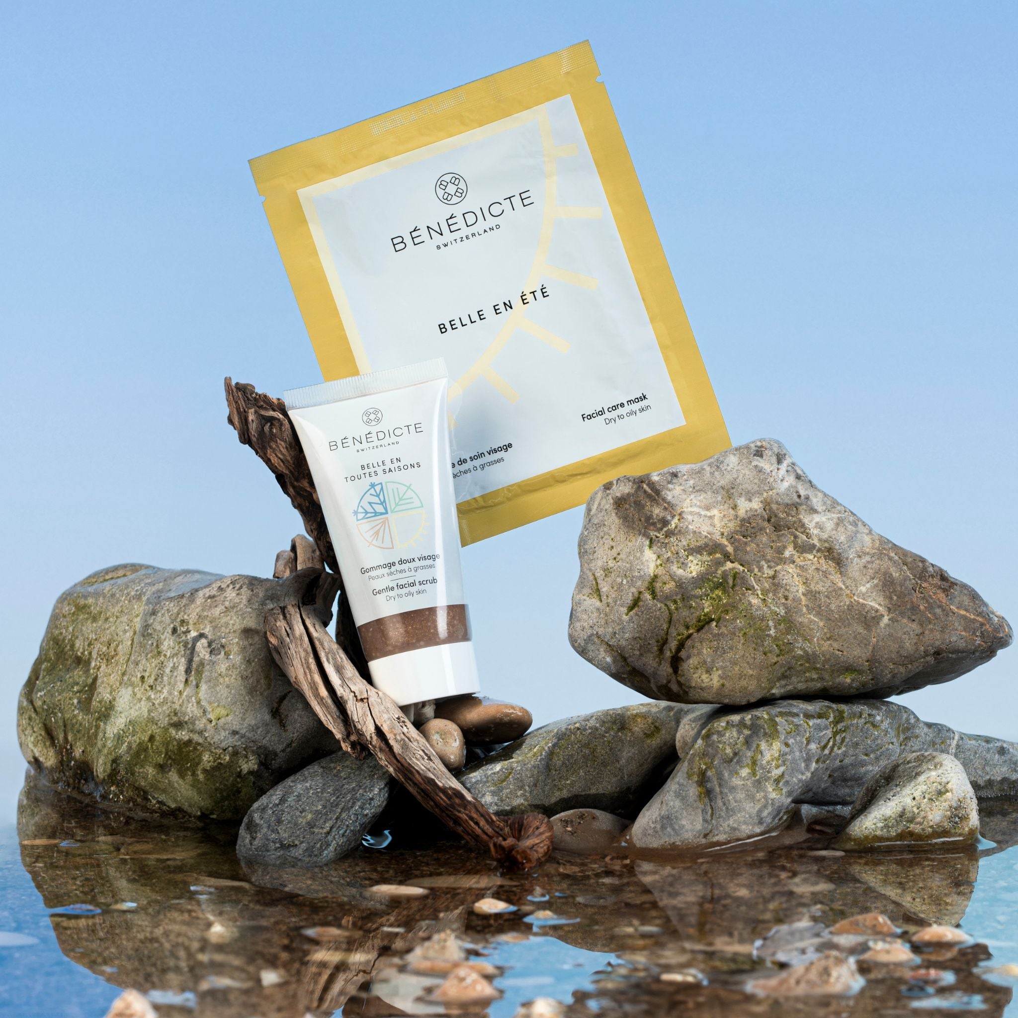 Visuel du gommage et du masque été photographiés sur des galets avec de l'eau sur un fond bleu