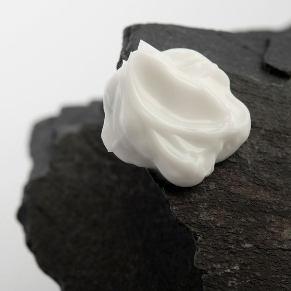 Gros plan sur la crème à mains posée sur un morceau d'ardoise